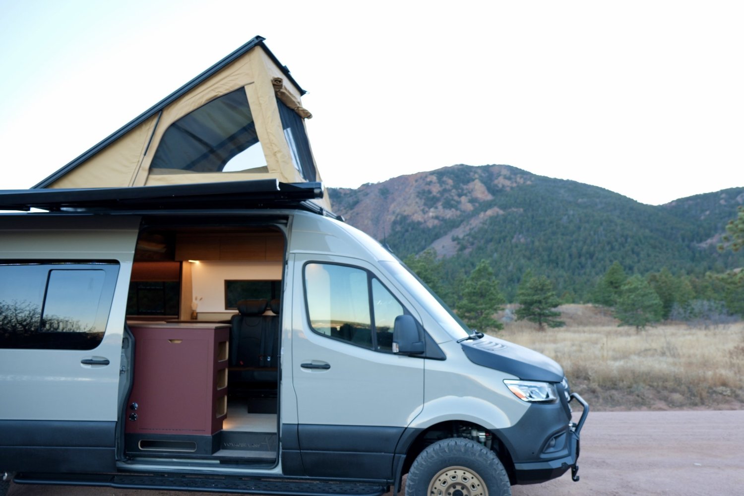 Sienna with its pop-top raised beside the mountains
