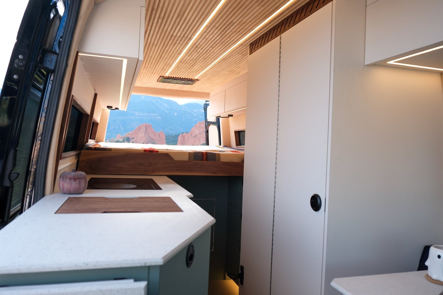 Verde interior with pale green cabinetry and a rear bed