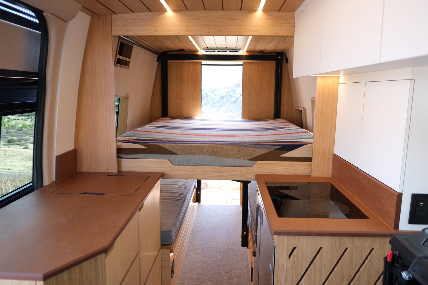 The Den elevator bed lowered above the rear seating area, viewed from the galley.