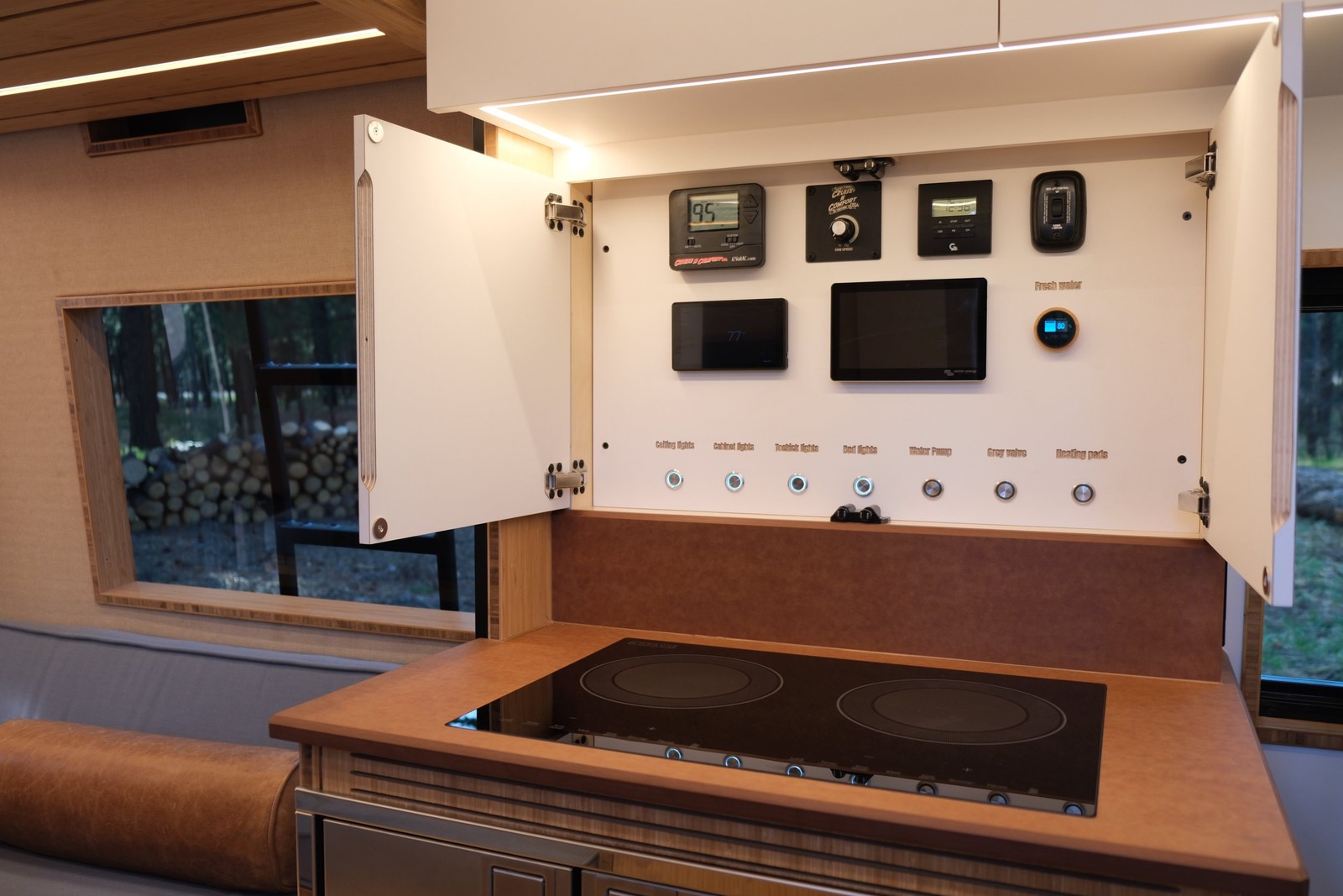 The Den open overhead control cabinet with system switches and displays above the sink.