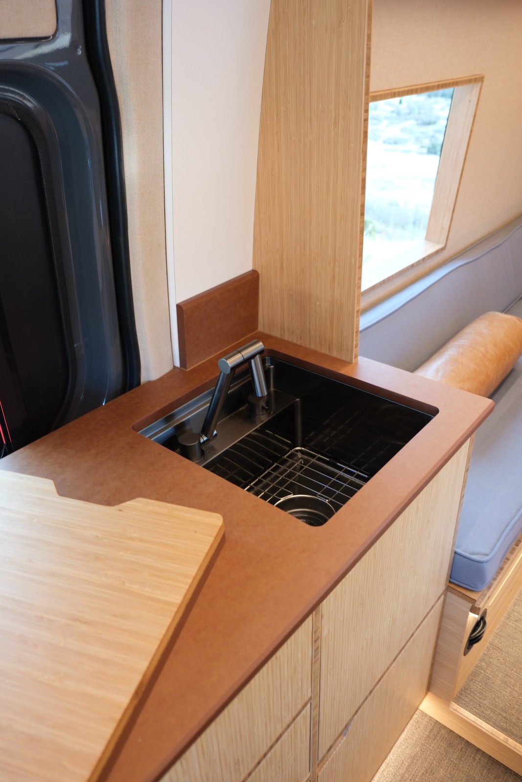 The Den open sink with its cutting-board cover moved to one side.