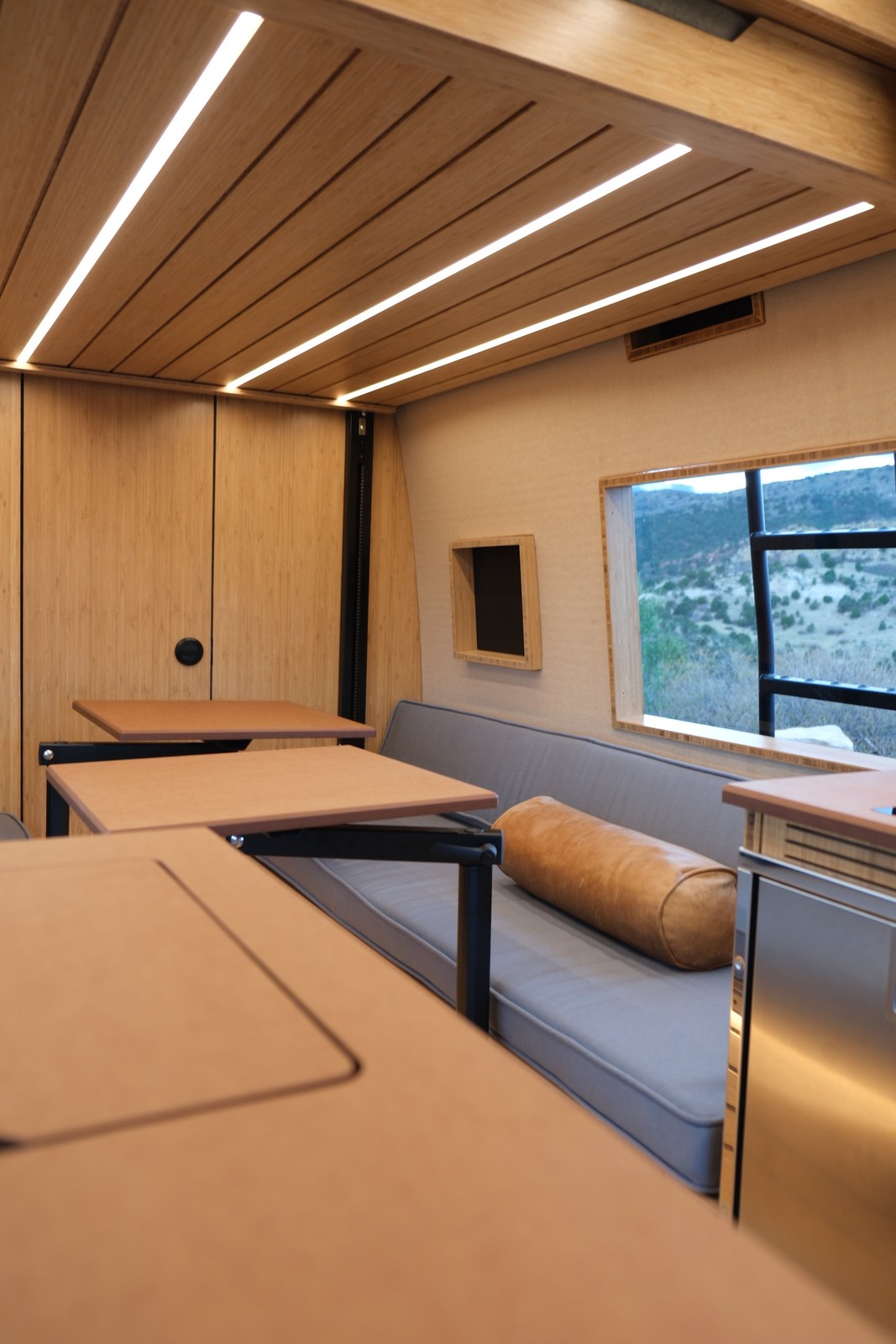 The Den cooktop set into the galley opposite a cushioned lounge bench.