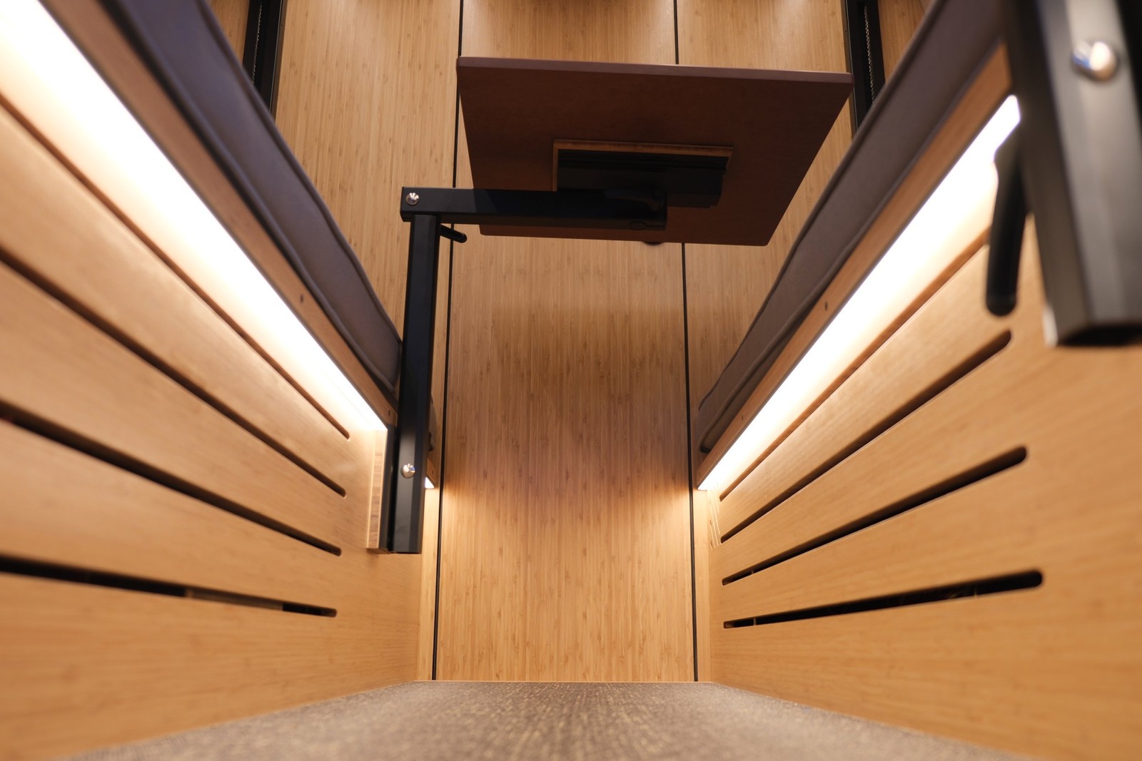The Den aisle with slatted bench fronts, wood flooring and a dining-table support.