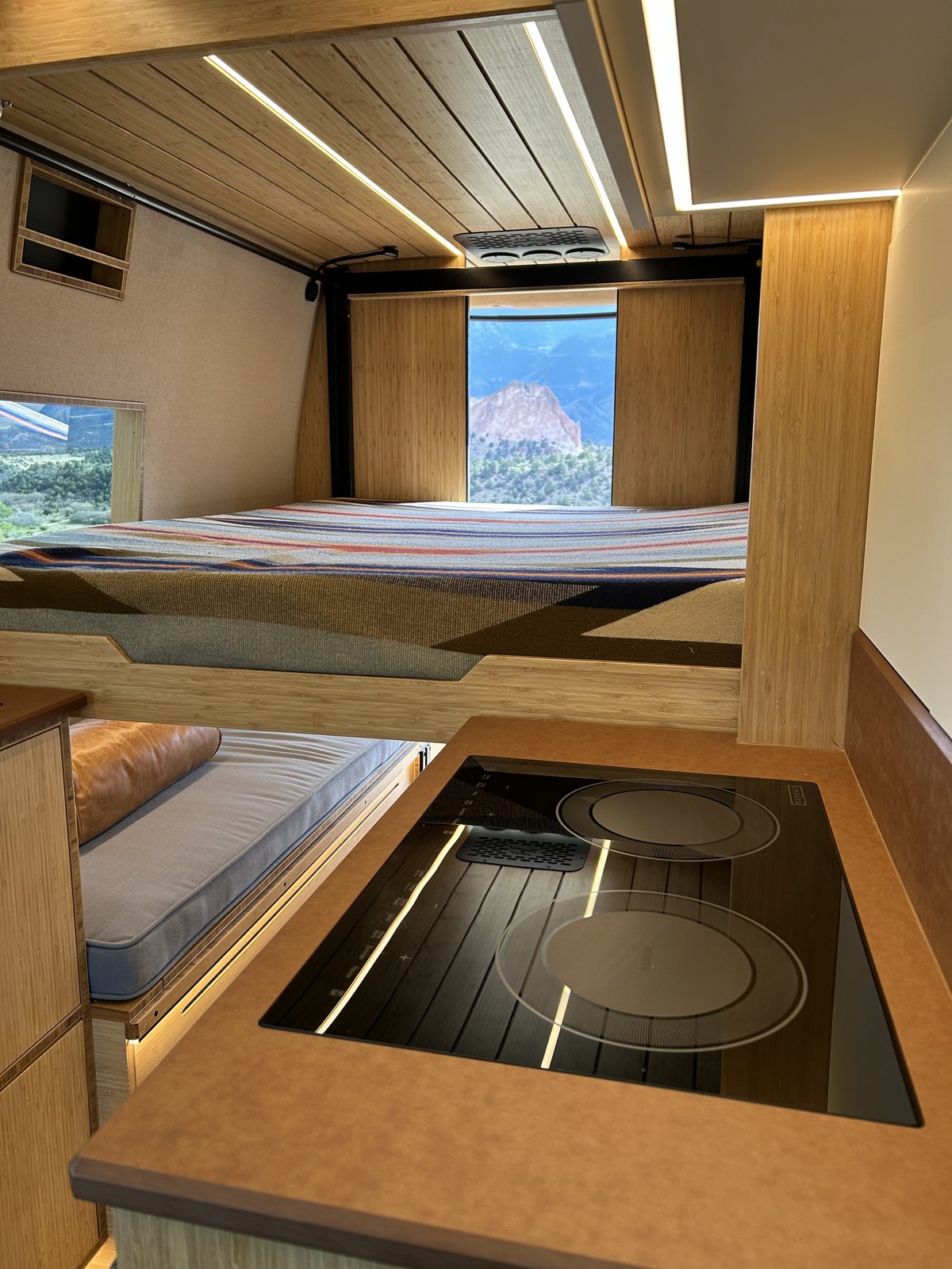 The Den elevator bed lowered above the rear lounge beside the galley cooktop.