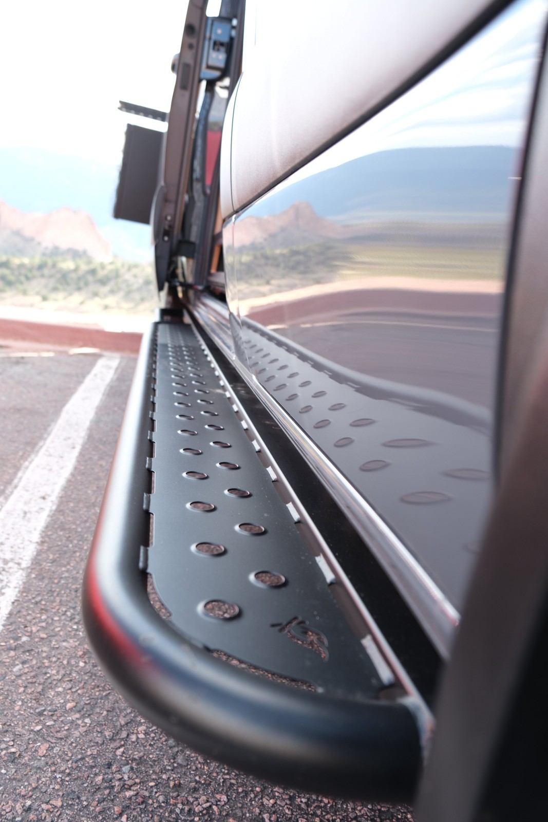 Close view of the Den metal side step below the sliding door.