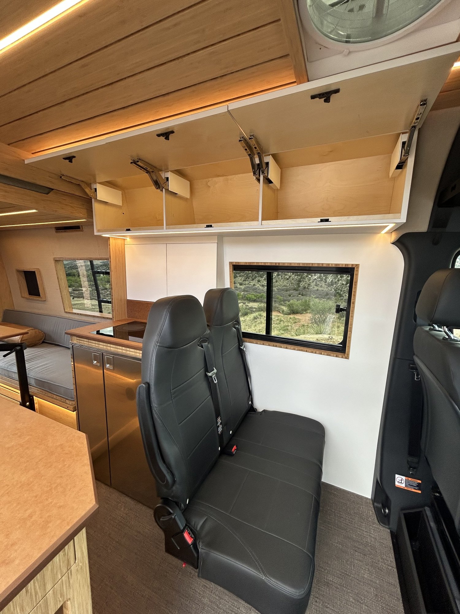The Den overhead cabinets open above its second-row passenger seats.