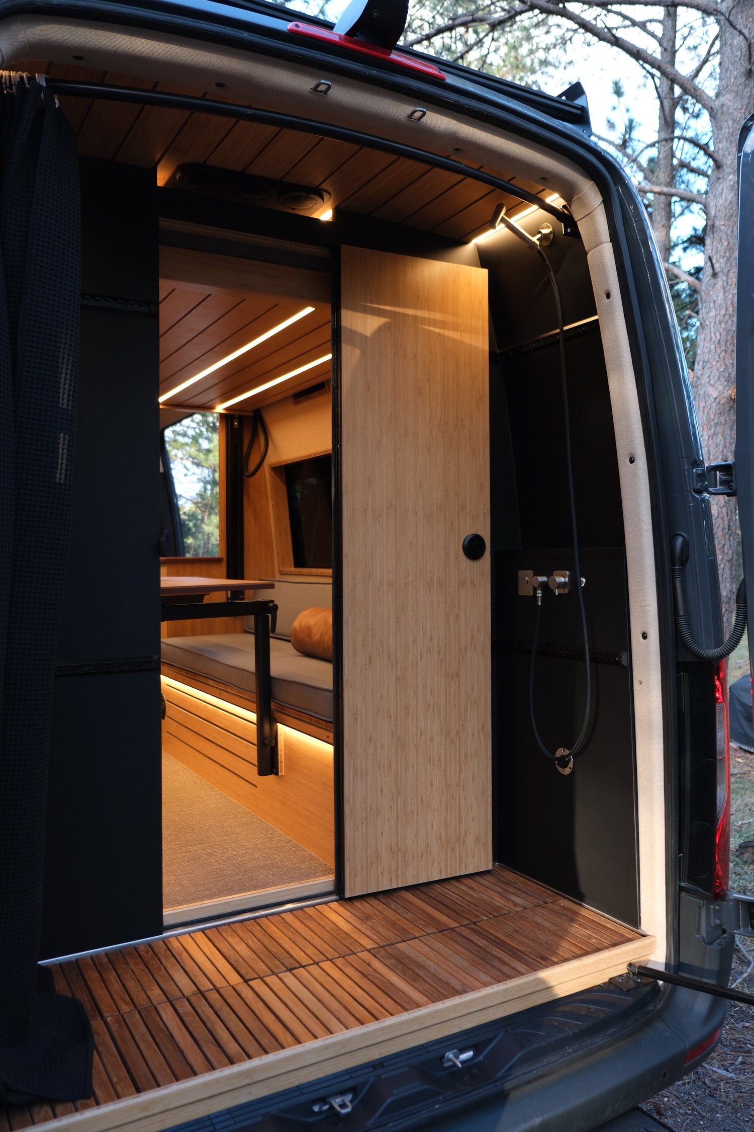 The Den rear wet bath with doors open, a wood slat floor and access through to the living space.