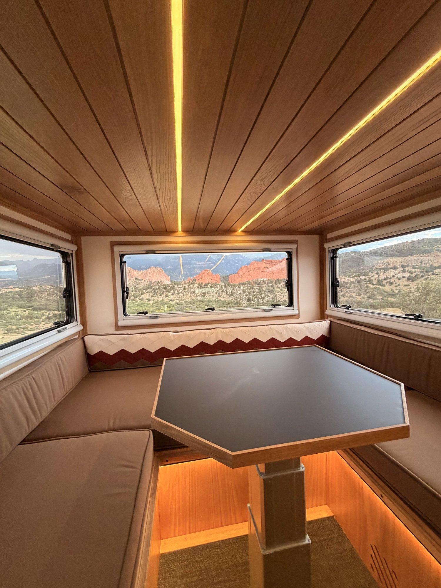 The Nest rear wraparound dinette with a table beneath three windows.