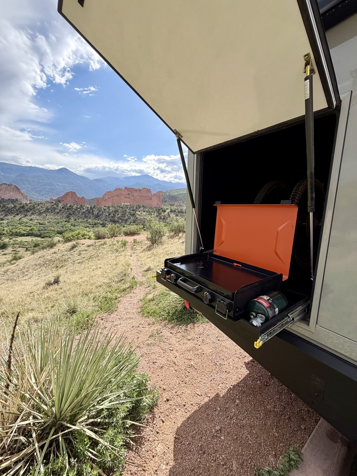 An open Nest exterior storage hatch with an orange case on its slide-out tray.