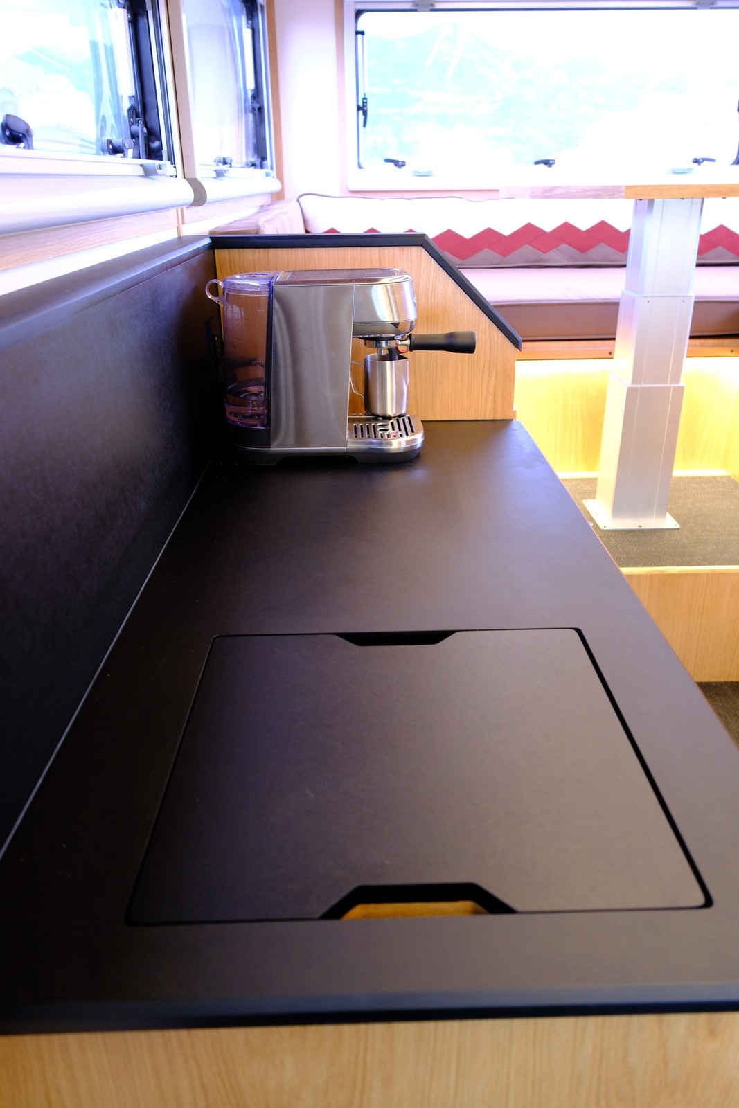 The Nest black galley countertop with a flush sink cover and coffee maker.