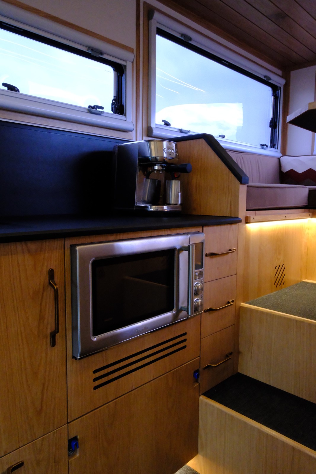The Nest wood galley cabinetry with a built-in microwave below the countertop.